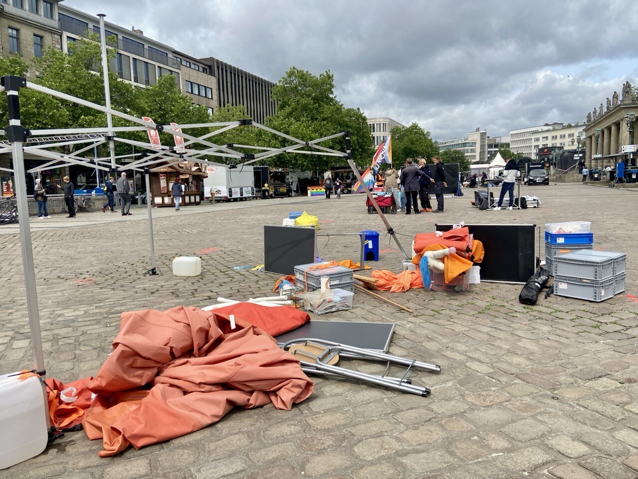 Sturm-verwüsteter Stand. Die Planen des Pavillions liegen neben dem Gestänge. Ein Bein des Pavillions ist stark verbogen. Tische stehen umgeworfen auf dem Kopfsteinpflaster.
